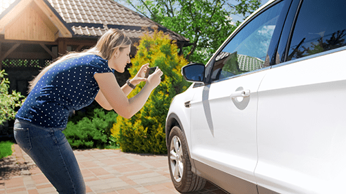 Woman taking picture of car